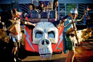 Members of BROS performing with an art car covered with skulls and lightning bolts